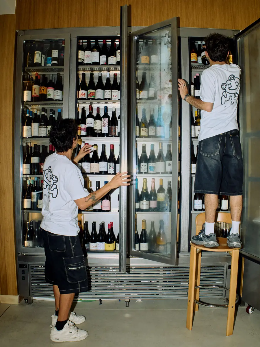 Two waiters picking wines from the Bar Amicks wine fridge