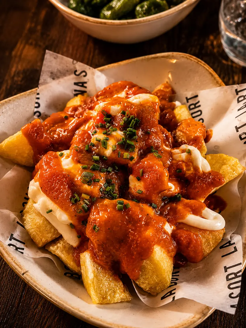 Patatas bravas servidas en plato de la casa