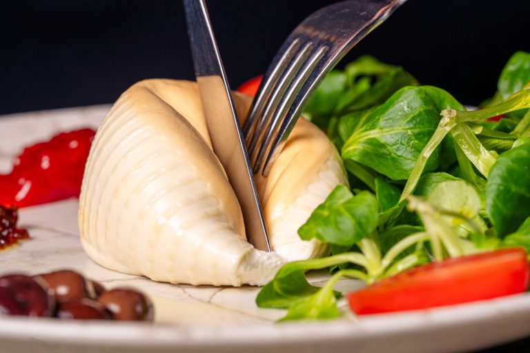 Burrata affumicata su letto di valeriana con pomodoro e cipolla caramellizzato e olive taggiasche