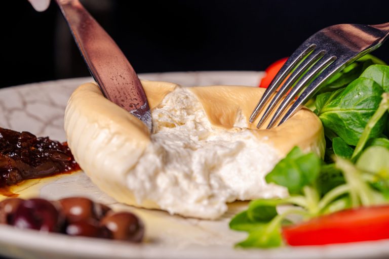 Burrata affumicata su letto di valeriana con pomodoro e cipolla caramellizzato e olive taggiasche