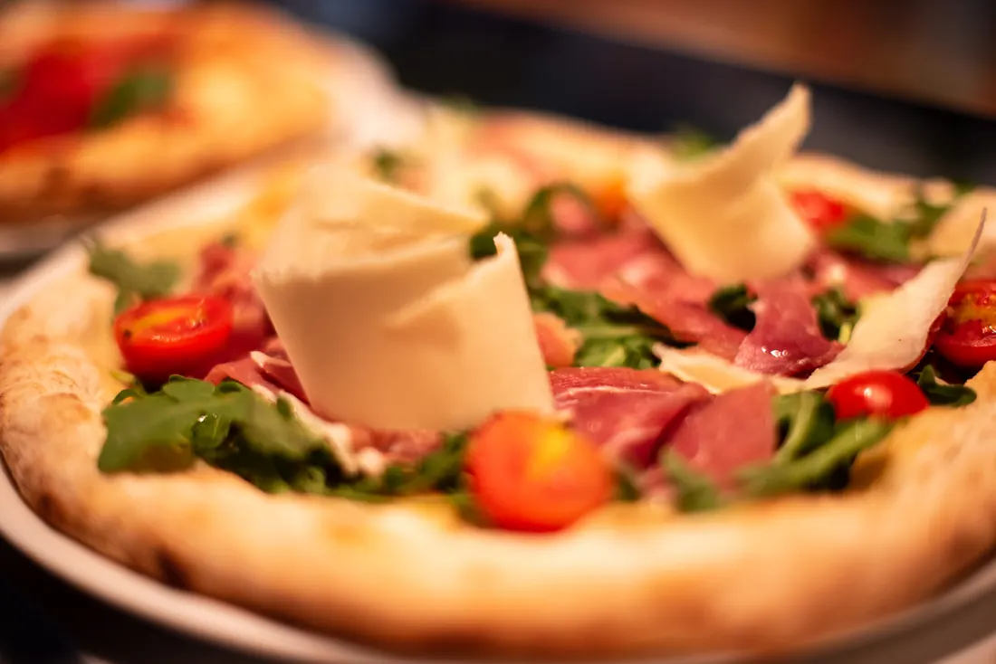 Pizza de jamón crudo con rúcula y lascas de parmesano